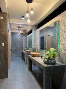 een badkamer met drie wastafels en een rij wastafels bij Cleofe's Place, Unique 3BR villa near Tagaytay City in Alfonso