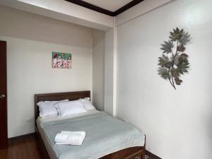 een slaapkamer met een bed met twee handdoeken erop bij Cleofe's Place, Unique 3BR villa near Tagaytay City in Alfonso