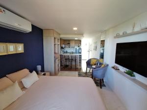 a bedroom with a large white bed and a living room at Hermoso Departamento completamente equipado in Colonia Mariano Roque Alonso +33 photos