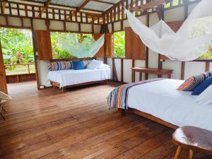 1 dormitorio con 2 camas y suelo de madera en Reserva Pakore Wera, en Bahía Solano