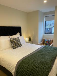 a bedroom with a large bed with a pillow and a window at Remarkables Retreat Apartment in Queenstown