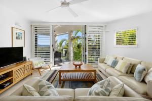a living room with a couch and a tv at 5 76 Upper Hastings Street in Noosa Heads
