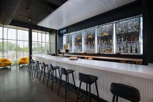 un bar con una fila de taburetes en una habitación en Aloft Austin Southwest, en Austin