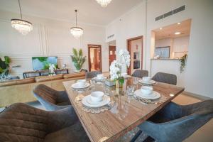 a dining room with a wooden table and chairs at FIRST CLASS 2BR with full DUBAI SKYLINE & SEA view in Dubai