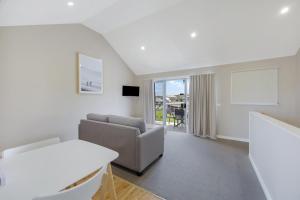 uma sala de estar com um sofá e uma mesa em Sea Foam Villas em Port Campbell