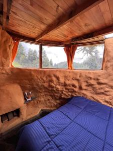 Ce lit se trouve dans un dortoir doté d'une fenêtre. dans l'établissement casa de los picapiedra, à Sesquilé
