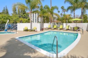 una piscina in un resort con tavoli e sedie di SpringHill Suites Pasadena Arcadia ad Arcadia