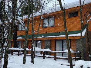 una cabaña de madera en el bosque con nieve en el suelo en Cabañas Bordenieve, en Las Trancas