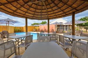 a patio with tables and chairs and a pool at Osprey Holiday Village Unit 104 in Exmouth