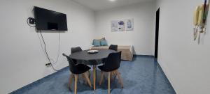 a room with a table with chairs and a television at Departamento Falucho 1 in Santa Rosa