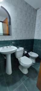 a bathroom with three toilets and a sink and a mirror at Departamento Falucho 1 in Santa Rosa +16 photos