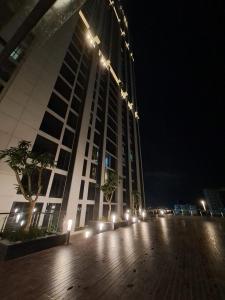 een groot gebouw met 's nachts lichten ervoor bij Apartemen pollux habibie in Kangboi