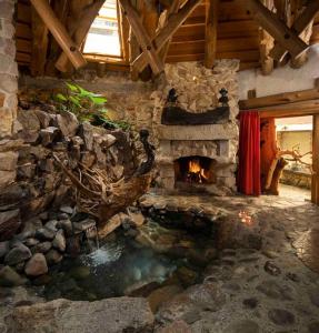 a living room with a stone fireplace and a pond at Casa Arte in Chimaltenango