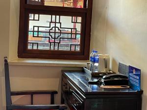 a desk with a telephone and a window in a room at Beijing Hyde Courtyard Hotel in Beijing