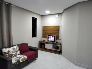 a living room with a couch and a television at Apartamento 2 Quartos - 5 minutos do São João de Petrolina in Petrolina
