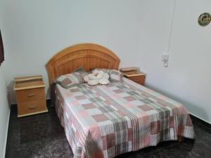 Casa com quarto e suíte في ساو ميجيل اركانخو: وجود حيوانات محشوة جالسة فوق السرير