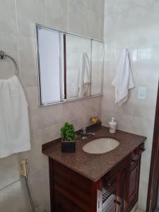 La salle de bains est pourvue d'un lavabo et d'un miroir. dans l'établissement Casa com quarto e suíte, à São Miguel Arcanjo