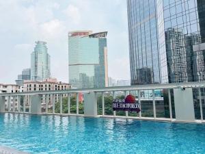 uitzicht op een zwembad in een stad met hoge gebouwen bij Ascott Guangzhou, Free Shuttle Bus For Canton Fair in Guangzhou