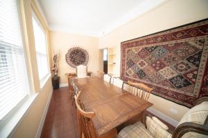 a dining room with a table and a rug on the wall at Club Salon Sleeps 10-20 Free Parking & TV in Chicago +19 photos