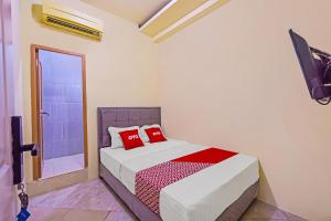 Tempat tidur dalam kamar di Super OYO 92687 Alnindo Makaliwe