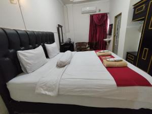 uma grande cama branca com duas toalhas em cima em SPOT ON 92695 My Kost Syariah 