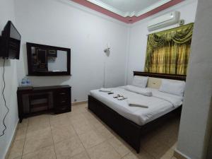 um quarto com uma cama e uma televisão em SPOT ON 92695 My Kost Syariah 
