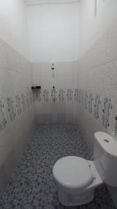 Łazienka z toaletą i podłogą wyłożoną kafelkami w obiekcie OYO 92701 Jasmine House Syariah w mieście Pekanbaru