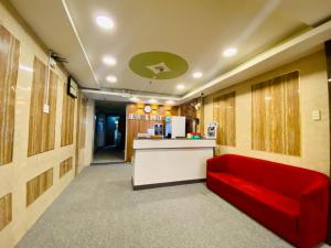 a waiting room with a red couch and a counter at Jewel Hotel in Ho Chi Minh City