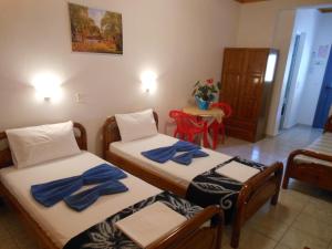 two beds in a room with blue towels on them at Pansion Giorgos & Rania in Skiathos