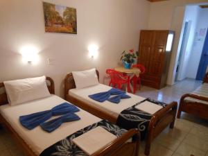 2 posti letto in una camera con asciugamani blu di Pansion Giorgos & Rania a Città di Skiathos