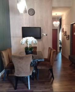 a dining room with a table with chairs and a television at Tiara Homestay in Kuantan