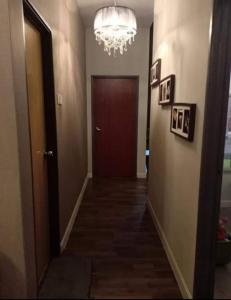 a hallway with a red door and a chandelier at Tiara Homestay in Kuantan