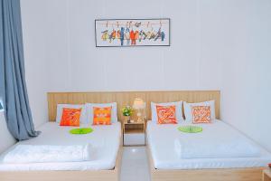 2 Betten nebeneinander in einem Zimmer in der Unterkunft Khách Sạn Toàn Yến - Nhơn Lý in Hưng Lương