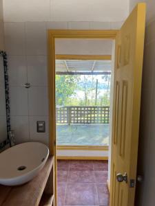 a bathroom with a sink and a view of a balcony at Cabaña aquelarre in Vichuquén
