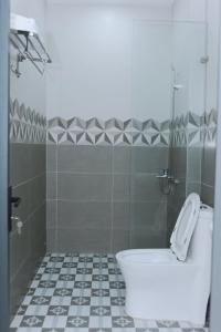 ein Badezimmer mit einem weißen WC in einer Dusche in der Unterkunft Khách Sạn Toàn Yến - Nhơn Lý in Hưng Lương