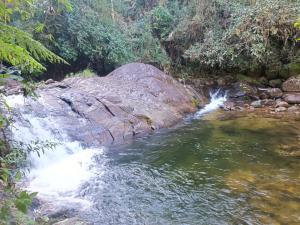 a waterfall in the middle of a river at Casa do Cedro - Sítio Cascatinha in Cruzeiro +18 photos