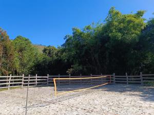 a volleyball net in front of a fence at Casa do Cedro - Sítio Cascatinha in Cruzeiro