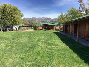 un cortile accanto a un edificio con un prato verde di Patagonia Bordelago a Puerto Ingeniero Ibáñez