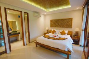 A bed or beds in a room at Taman Amartha Hotel