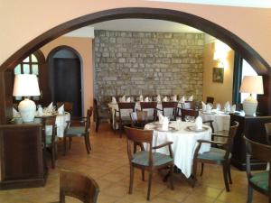 a dining room with tables and chairs and a brick wall at Casale Maginulfo in Roccamandolfi