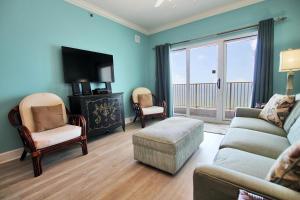 a living room with a couch and chairs and a television at Seawind 1205 in Gulf Shores