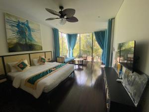 une chambre avec un grand lit et un ventilateur de plafond dans l'établissement Villa Container, à Vung Tau
