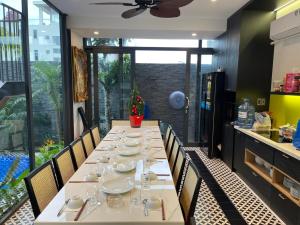 une salle à manger avec une longue table et des chaises dans l'établissement Villa Container, à Vung Tau