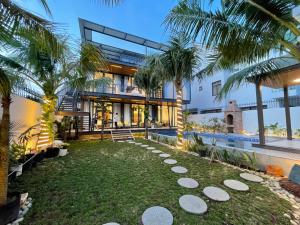 - une vue sur l'extérieur d'une maison avec des palmiers dans l'établissement Villa Container, à Vung Tau