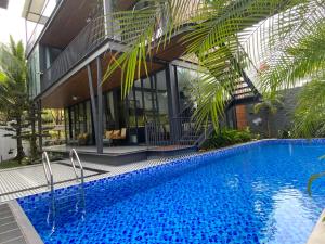une maison avec piscine devant un immeuble dans l'établissement Villa Container, à Vung Tau