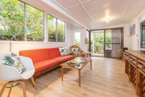 a living room with a red couch and windows at Trade Winds in Elizabeth Beach +8 photos