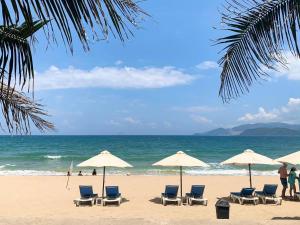 a beach with chairs and umbrellas and the ocean at Oron Nhatrang House in Nha Trang