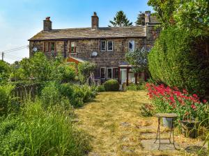 una casa antigua con un jardín delante de ella en Lavender Cottage en Kirkburton