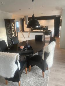 a dining room with a black table and black chairs at Stort luftig hus i Fredrikstad in Fredrikstad