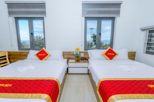 2 letti in una camera con finestre di Golden Sea Quy Nhơn a Quy Nhon